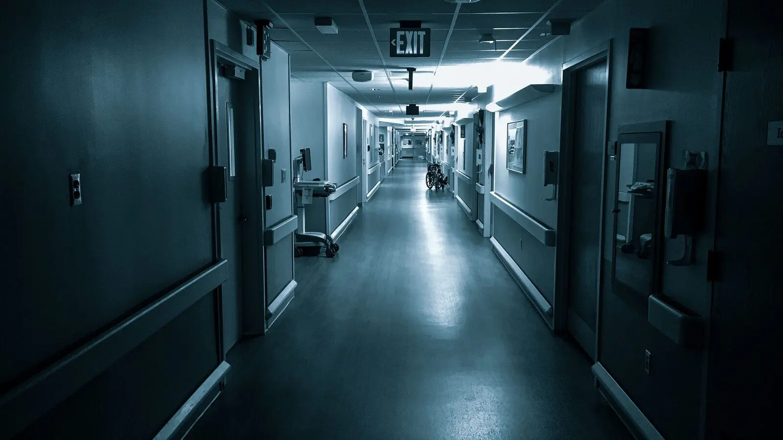 Corridoio d'ospedale deserto di notte, illuminato solo dalle luci di servizio