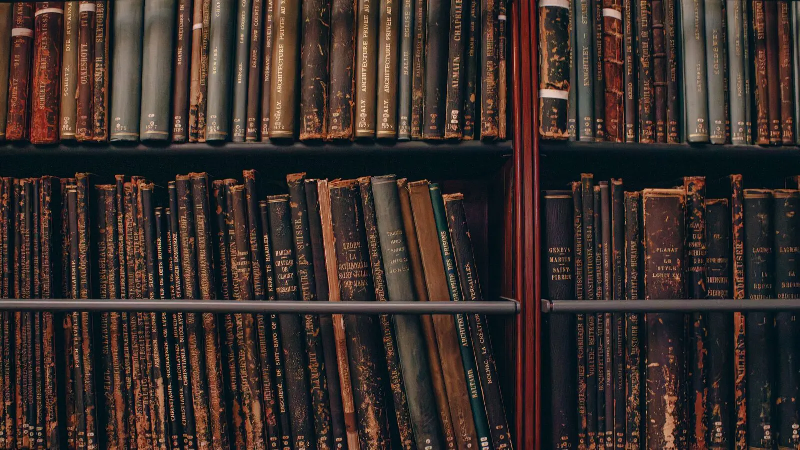 Libri vecchi allineati su scaffali di legno