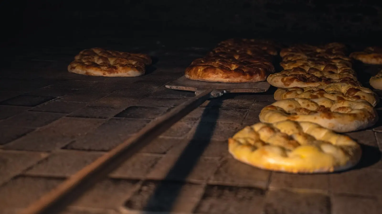 Pagnotte dorate dentro un forno a legna in pietra
